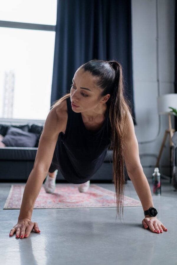 Fit woman performing push-ups indoors showcasing strength and determination.